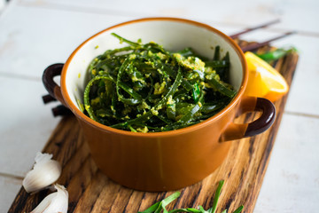 Japanese asian chuka laminaria seaweed salad with dressing of onion, garlic, lemon, sesame seeds and oil. Traditional lunch or dinner. Used to eat with chopsticks. Raw, vegan, vegetarian healthy food