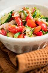 Fresh vegetables Greek salad with tomatoes, cucumbers, onion slices and sprouts. Served with olive oil. Raw vegan vegetarian healthy food on lunch or dinner