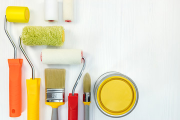 home renovation. set of paint brushes, rollers and other tools on white wooden background