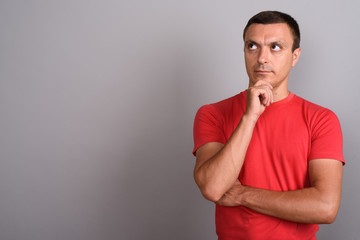 Man wearing red shirt against gray background