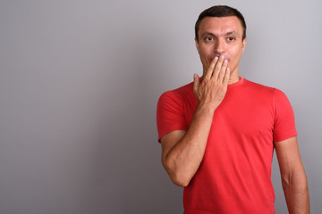 Man wearing red shirt against gray background