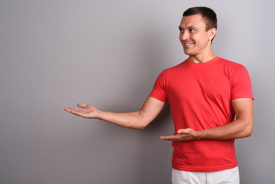 Man Wearing Red Shirt Against Gray Background