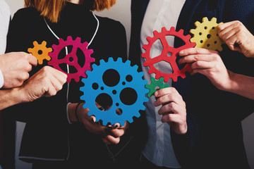 Business team connect pieces of gears. Teamwork, partnership and integration concept