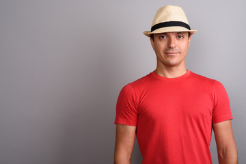 Tourist man wearing hat and red shirt against gray background