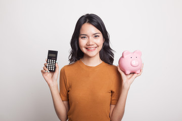 Asian woman with calculator and piggy bank.