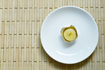Chinese cake filled mashed sweet bean topping black and white sesame in aluminum tray on white plate