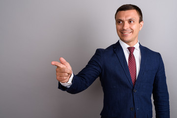 Businessman wearing suit against gray background