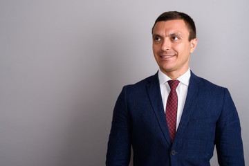 Businessman wearing suit against gray background