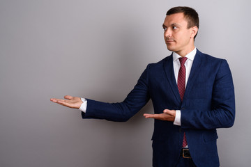 Businessman wearing suit against gray background