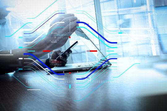 designer hand working and smart phone and laptop on wooden desk in office with london city background