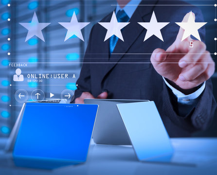 Five stars (5) rating with a businessman is touching virtual computer screen.For positive customer feedback and review with excellent performance.