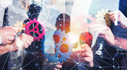Business team connect pieces of gears. Teamwork, partnership and integration concept with network...