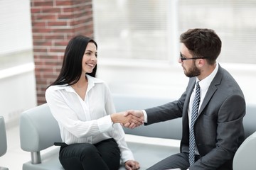 handshake of manager and client sitting in the office lobby.