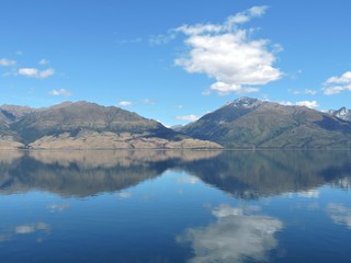 Glassy lake reflecting mountains and blue sky, Lake Wanaka, New Zealand
