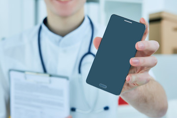 Male doctor's hand showing a blank smart phone screen.