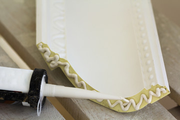 Close-up detail of decoration molding with glue adhesive before installation in interior renovation. © bilanol