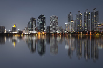 cityscapes building in modern city bright at night with skyline and water reflection.
