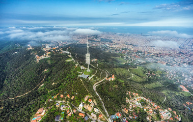 Naklejka premium Barcelona aerial wide angle view from the hills above the city, Spain. Clouds below the horizon