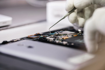 Fototapeta na wymiar Work with a microscope. Microelectronics device. Close-up hands of a service worker repairing modern smartphone. Repair and service concept.