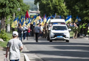 мальчик идущий на встречу демонстрации с флагами и милицией