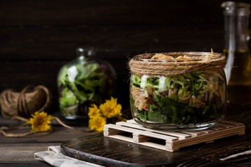 Salad from sprouts of sprouted soy and dandelion leaves in a jar