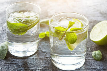 Mojito cocktail. Iced drink with lime and mint. Dark stone background. 