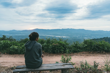 Back view of asian woman relaxing on the top hill.