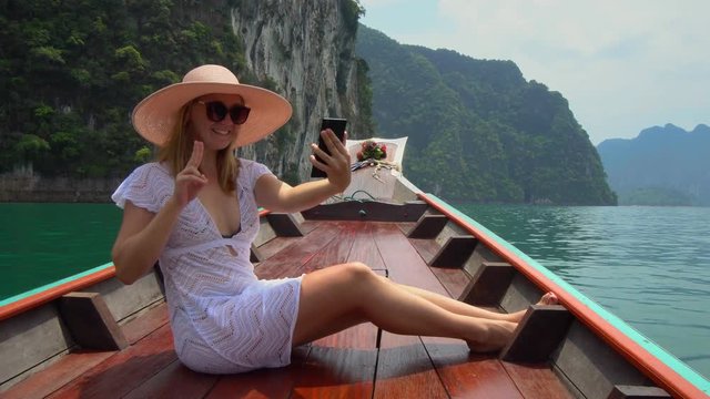 Young Female Tourist Taking Selfie of Huge Turquoise Lake with Limestone Cliffs Rising from the Water. Caucasian Woman in Hat Riding Longtail Boat at Cheow Lan Lake in Khao Sok National Park, Thailand