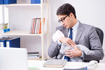 Naklejka premium Businessman looking after newborn baby in office