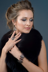 young girl in an expensive fur coat with luxurious silver jewelry