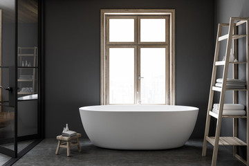 Fototapeta na wymiar White bathtub in a luxury dark bathroom