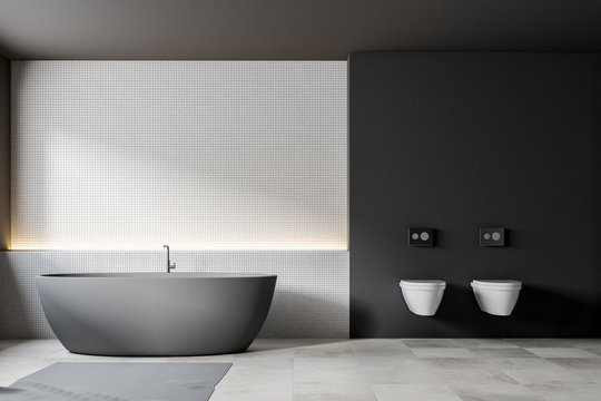 Gray boat shaped bathtub, white tiles, toilet
