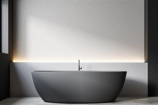 Gray boat shaped bathtub, white tiles