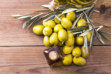 olives and bottle of extra virgin olive oil on wood