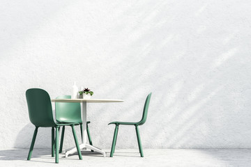 Table with green chairs standing outside summer