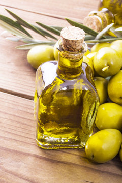 olives and bottle of extra virgin olive oil on wood