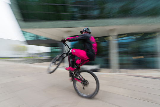 Sportlicher Radfahrer in der Innenstadt mit Bewegungsunschärfe