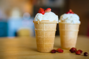 ice cream in waffle cups with wild strawberries
