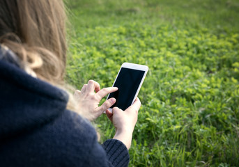 Close up of women's hands holding cell telephone with blank copy space screen for your advertising text message or promotional content