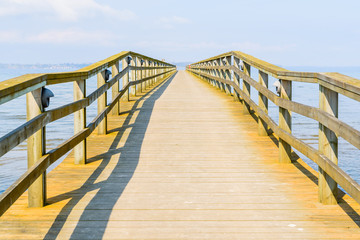 Borstahusen, Sweden - Long and empty wooden pier on a sunny day with haze.