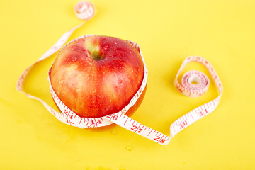 Measuring tape wrapped around a red apple
