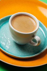 Cup of coffee on colorful tableware