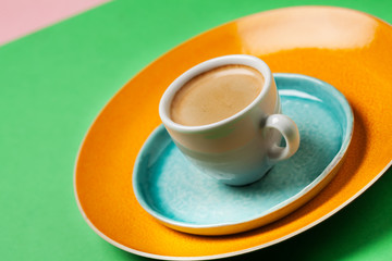 Cup of coffee on colorful tableware
