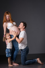 Husband and pregnant wife with a child