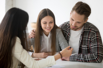 Millennial couple considering mortgage investment loan, planning wedding at meeting with financial...