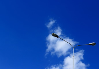 Lighting lamp, street lights, lamppost against the vast blue sky with cloud - abstract minimalism background wiht copy space. Lanterns on outdoor