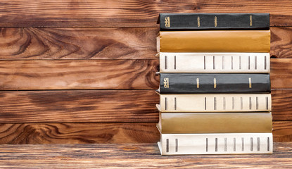 Stack of books on the wooden background.
