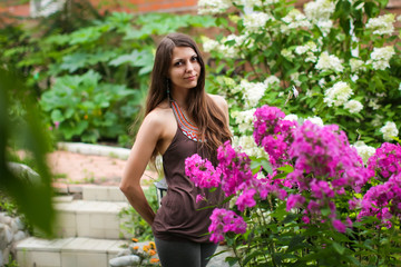 close-up Outdoor Portrait Of Beautiful Pretty Woman In Spring Garden. Magic beautiful brunette woman with a wreath of white fresh flowers in a blooming garden. portrait of happy smiling girl.