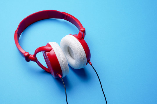 Photo of red with white headphones for music close-up on blue background