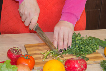 woman hands cutting vegetables on kitchen blackboard. Healthy food. Woman preparing vegetables, cooking healthy meal in the kitchen